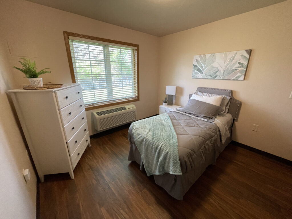Bedroom with Bed and Dresser at Azalea Place